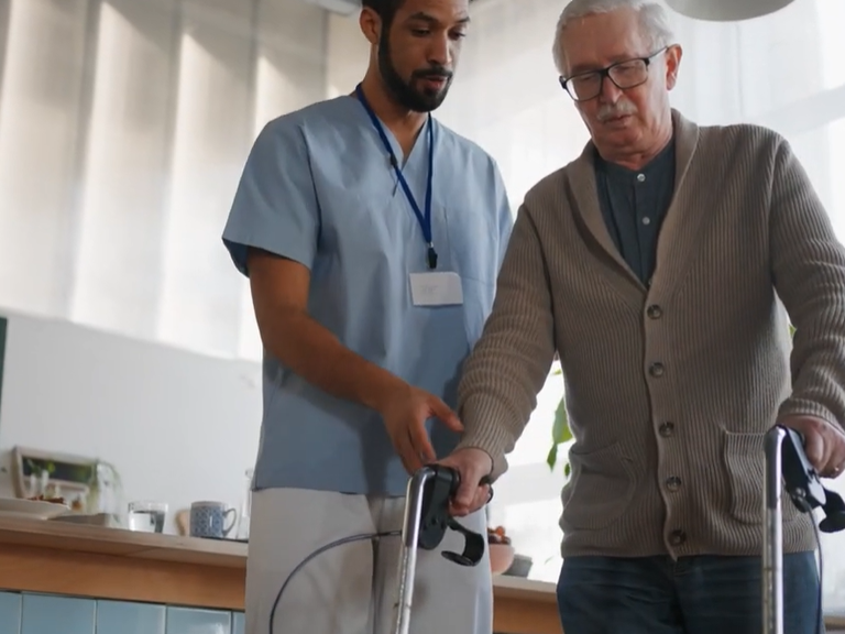 Caregiver helping man with walker